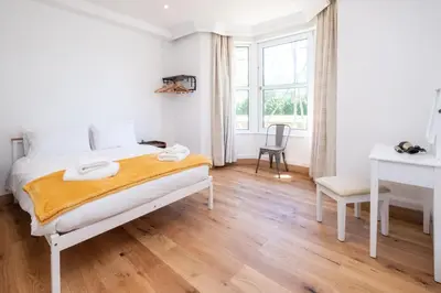 a white bedroom with a bed and a desk at Birch - Three Tuns Apartments - Pettistree, Wickham Market - by Aldeburgh Coastal Cottages in Pettistree