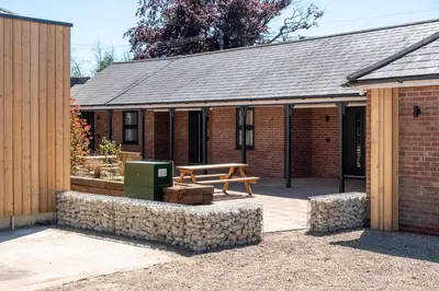 a brick building with a picnic table in front of it at Birch - Three Tuns Apartments - Pettistree, Wickham Market - by Aldeburgh Coastal Cottages in Pettistree