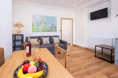 a living room with a table with a bowl of fruit at Birch - Three Tuns Apartments - Pettistree, Wickham Market - by Aldeburgh Coastal Cottages in Pettistree