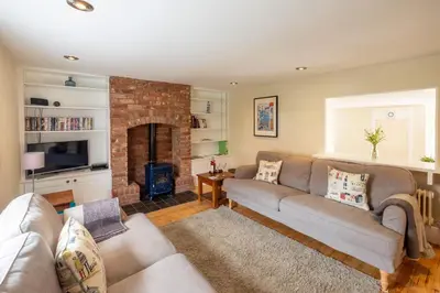 a living room with a couch and a fireplace at Little Tern Cottage in Aldeburgh