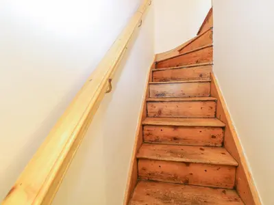 a staircase with wooden railings in a room at 3 Station Cottages in Wymondham