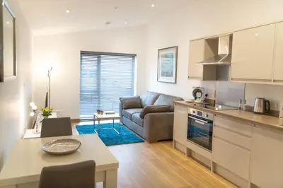 a kitchen and living room with a couch and a table at Citystay Living - Franklin House in Cambridge