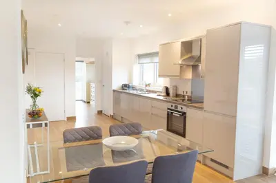 a kitchen with a glass table and some chairs at Citystay Living - Franklin House in Cambridge