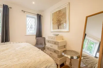 a bedroom with a bed and a mirror and a chair at Delightful CENTRAL Duplex - 2 Mins To Station in Cambridge