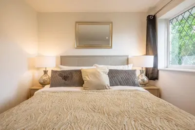 a bedroom with a bed with two lamps and a mirror at Delightful CENTRAL Duplex - 2 Mins To Station in Cambridge