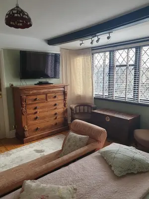 a living room with a tv and a dresser at Harry's bed and breakfast in Cambridge