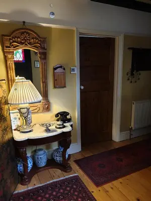 a room with a table with a lamp and a mirror at Harry's bed and breakfast in Cambridge