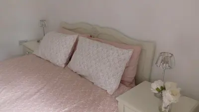 a bedroom with a bed with pink pillows and a table at The Lodge Greatwood in Ipswich