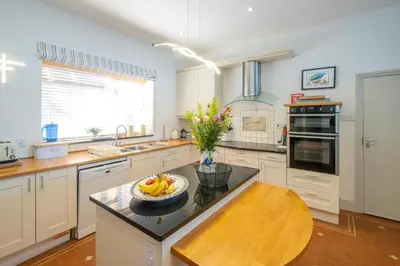 a kitchen with a bowl of fruit on a counter at Stoney Beach - Aldeburgh Coastal Cottages in Aldeburgh