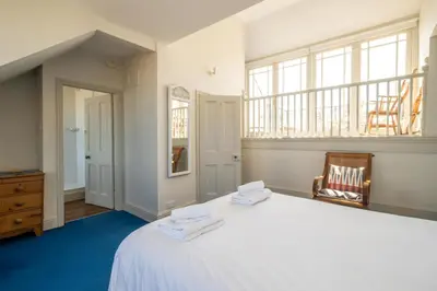 a bedroom with a large white bed and a window at Stoney Beach - Aldeburgh Coastal Cottages in Aldeburgh