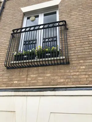 a window with a black railing and flowers on it at Adam And Eve Street Apartment in Cambridge