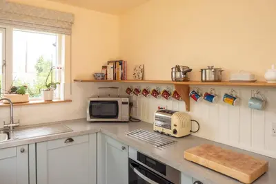 a kitchen with a counter with a toaster oven and a microwave at Willow House in Knodishall, Sleeps 7 - Only a short drive from Aldeburgh, Thorpeness & Snape Maltings - Managed by Aldeburgh Coastal Cottages in Aldringham