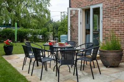 a table and chairs on a patio at Willow House in Knodishall, Sleeps 7 - Only a short drive from Aldeburgh, Thorpeness & Snape Maltings - Managed by Aldeburgh Coastal Cottages in Aldringham
