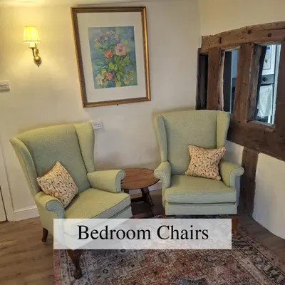 two chairs and a table in a living room at The Abbey Hotel & Apartments in Bury Saint Edmunds