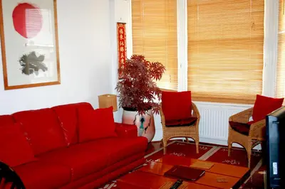 a living room with a red couch and chairs at Hartland 2-Bedroom Apartments with Bfast and Parking in Southend-on-Sea