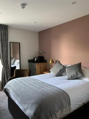 a bedroom with a large bed and a mirror at The Three Pickerels in Mepal