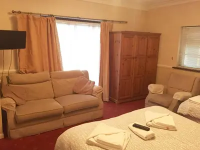 a bedroom with a couch and a bed and a window at Welbeck Hotel - Close to Beach, Train Station & Southend Airport in Southend-on-Sea