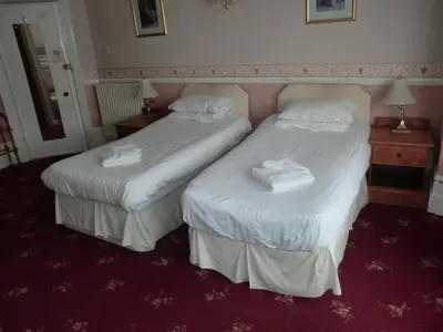 two beds in a hotel room with towels on them at Welbeck Hotel - Close to Beach, Train Station & Southend Airport in Southend-on-Sea