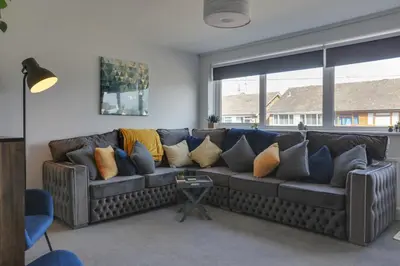 a living room with a couch with pillows on it at Niche Sunrise Townhouse in Chelmsford