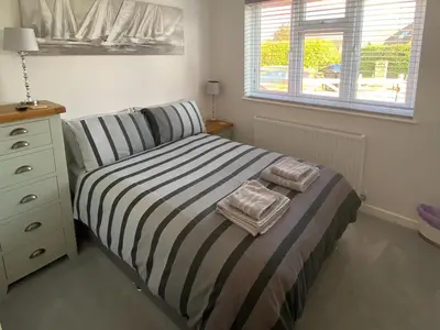 a bedroom with a bed and a dresser and a window at Rainbows End in Saint Lawrence