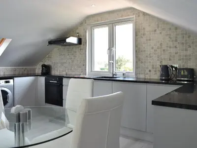 a kitchen with white appliances and a window at Rainbows End in Saint Lawrence