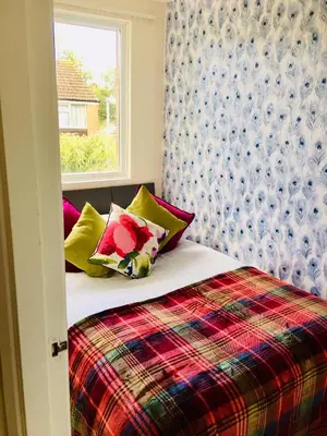 a bedroom with a bed with pillows and a window at Homely & Cosy 3 Bed Birch Close House with Free Parking, Garden & Sleeps 8 in Cambridge