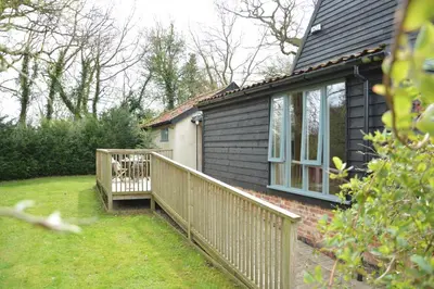 a house with a deck with a dog on it at Yew Tree Farm Stable, Worlingworth in Worlingworth