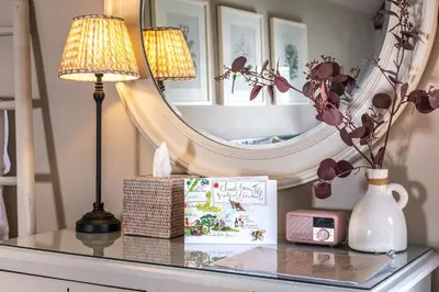 a glass table with a lamp and a mirror at Church Farm B&B Suffolk in Great Welnetham