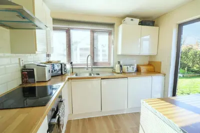 a kitchen with white cabinets and a sink at Pet Friendly Home in Chelmsford-Hot Tub-Sleeps 6 in Latchingdon and Snoreham