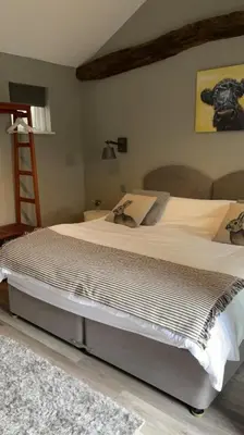a large bed in a bedroom with a ladder at The British Queen, Meldreth in Meldreth