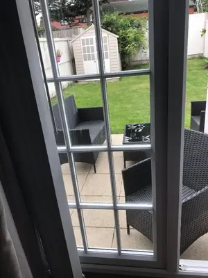 a window view of a patio with chairs and a table at Villa Belle Three bedrooms Basildon in Basildon