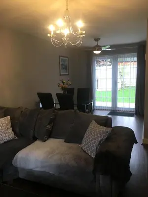 a living room with a couch and a chandelier at Villa Belle Three bedrooms Basildon in Basildon
