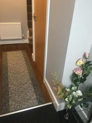 a hallway with a door and a vase with flowers at Villa Belle Three bedrooms Basildon in Basildon