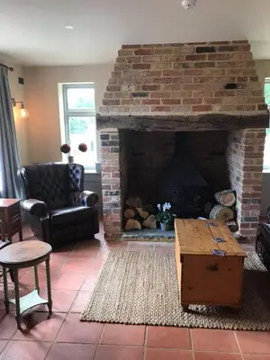 a living room with a large brick fireplace at The Cavendish Five Bells in Cavendish