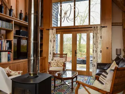 a living room with a wood stove in a room at Ivy Todd Barn in Ashdon