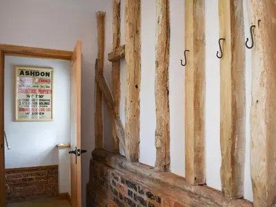 a room with wooden beams on the wall at Ivy Todd Barn in Ashdon