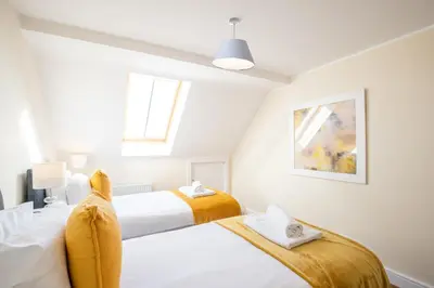 two beds in a bedroom with white walls at Velvet 2-bedroom apartment, Clockhouse, Hoddesdon in Hoddesdon