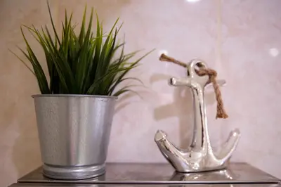 a metal watering can with a plant in it at Velvet 2-bedroom apartment, Clockhouse, Hoddesdon in Hoddesdon