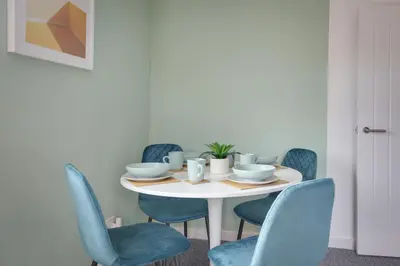 a dining room table with blue chairs and a white table at George Suite - Central Location - Free Allocated Parking in Chelmsford