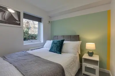 a bedroom with a bed and a window at George Suite - Central Location - Free Allocated Parking in Chelmsford