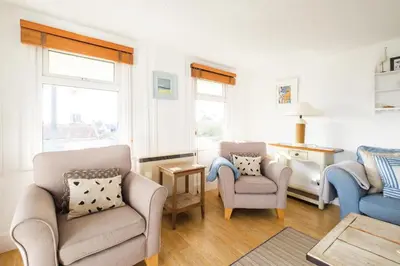 a living room with two chairs and a table at Shore Cote, Thorpeness in Thorpeness