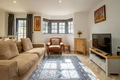 a living room with a couch and a tv at 5 Oakes Court in Thorpeness