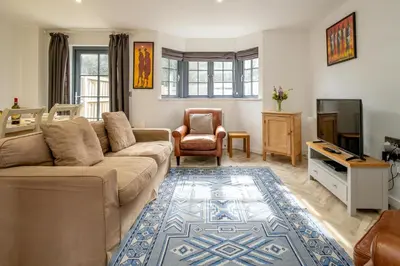 a living room with a couch and a tv at 5 Oakes Court in Thorpeness