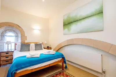 a bedroom with a bed and a painting on the wall at The Tower in Thorpeness