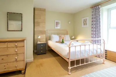 a bedroom with a bed with a dresser and a mirror at The Tower in Thorpeness