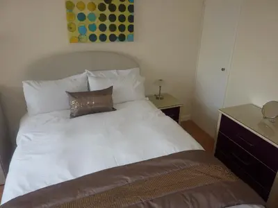 a white bed with a pillow on top of it at WynnStay Studio Apartments in Southend-on-Sea