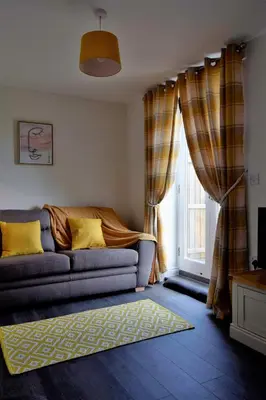 a living room with a couch and a window at Woodlands View in Halesworth