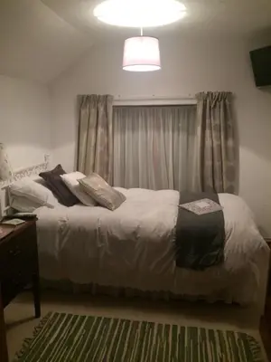 a bedroom with a bed and a window with curtains at The Elms in East Harling