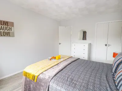 a bedroom with a bed with a yellow and gray blanket at Village Retreat in Ely
