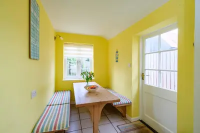 a small room with a table and a window at 4 Old Homes, Thorpeness - Only a stones throw from the beach - Aldeburgh Coastal Cottages in Thorpeness